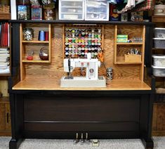 a sewing machine sitting on top of a wooden table next to shelves filled with craft supplies