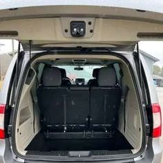 the back end of a silver van with two seats in it's cargo area