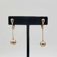 "Vintage 1970s Sarah Coventry Gold Tone Bead & Chain Dangle Clip On Earrings These pretty earrings will make a versatile addition to your jewelry wardrobe.  The clips are affixed to a shining gold-tone teardrop-shaped stud.  A chain is affixed to the clip from which dangles a large gold-tone spherical bead.  These earrings are in excellent, like-new condition.  Dimensions:  1 3/4\" x 3/8\" Clasp: Clip Ons Markings: Sarah Cov Condition:  Excellent - like-new All of my shop items are pre-owned vintage.  All pieces should be expected to have some vintage wear unless otherwise stated.   Great for the vintage & costume jewelry lover!  Be sure to check out our other vintage jewelry listings! Looking for something that isn't listed in my shop? Send me a message! I have thousands of pieces in stoc Dangle Ball Chain Jewelry, Formal Long Drop Dangling Beads Earrings, Formal Long Drop Earrings With Dangling Beads, Formal Metal Jewelry With Ball Chain, Vintage Gold Chandelier Earrings With Dangling Beads, Jewelry Wardrobe, Sarah Coventry, Bead Chain, Retro Women