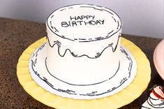 a birthday cake sitting on top of a yellow plate