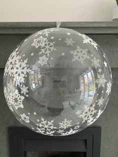 an inflatable ball with snowflakes on it sitting on top of a fireplace