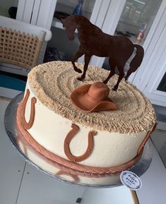 there is a cake with a horse on top and a cowboy hat on the top