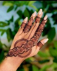 a woman's hand with henna tattoos on it