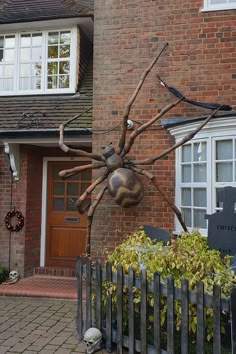 a large spider statue sitting in front of a house