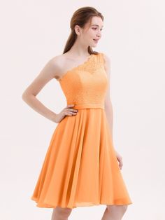 a woman in an orange dress posing for the camera with her hands on her hips