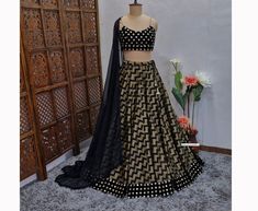 Made to Order/Measurement/Custom Order Lehenga - Color : Black - Fabric : Chevron Khadi Silk - Flared Paneled Lehenga skirt with Black Velvet Faux Mirror Border - Black Velvet Faux Mirror Spaghetti Blouse - Black dupatta with Fringes  - Drawstring closure with designer latkan - Can can attached PLEASE NOTE: BUYERS ARE RESPONSIBLE FOR ANY CUSTOMS AND IMPORT TAXES THAT MAY APPLY. Fabric Care : Dry Clean Only Disclaimer: Please note the photographs are taken by mobile camera in sunlight The actual color of the product might slightly differ due to exposure of light or monitor's display Shipping: This is made to order product. We customize the pattern of the dress to suit your style and fitting. Once you place the order we will provide you with a template for measurements (to be taken in inches Designer Black Lehenga With Pallu, Black Fitted Sharara For Diwali, Fitted Black Sharara For Diwali, Black Fitted Bollywood Sharara, Fitted Black Traditional Wear For Reception, Black Floor-length Saree With Cutdana, Black Floor-length Designer Lehenga, Fitted Black Sharara For Reception, Fitted Black Sharara For Festivals