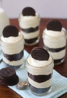 oreo cookies and cream desserts in small glass jars on a table with spoons