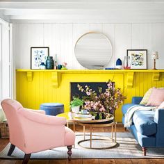 a living room filled with furniture and a fire place in front of a yellow fireplace