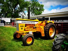 a large yellow tractor parked in the grass