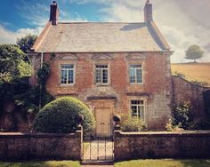 an old brick house with ivy growing on it's walls and gated yard