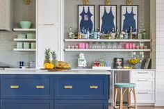 a kitchen with blue cabinets and yellow stools