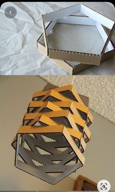 an origami box hanging from the ceiling with tape on it and another paper box in the background