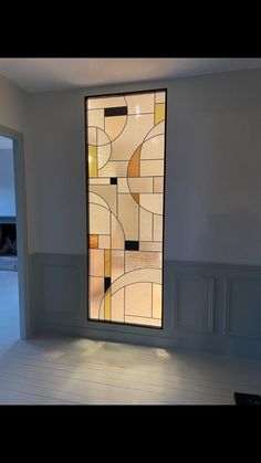 an empty room with a large stained glass window on the wall and white flooring