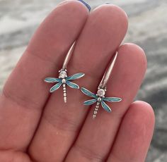 pair of dragonfly earrings in sterling silver with blue enamel and clear crystal stones on each end