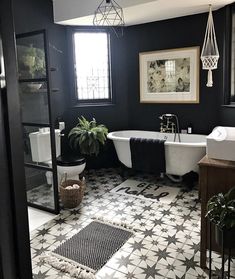 a black and white bathroom with a claw foot tub