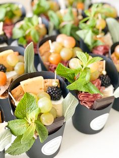 small trays filled with different types of fruit and cheese on toothpick sticks