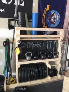 a rack with plates, kettles and barbells on it