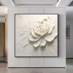 a large white flower is hanging on the wall in an empty room with tile flooring