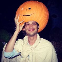 a man wearing a pumpkin hat on his head