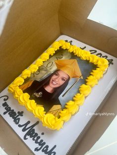 a cake in the shape of a graduation photo with yellow icing and decorations on it