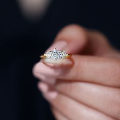 a person holding a diamond ring in their hand