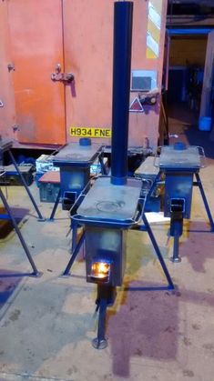 three blue stoves sitting on top of metal stools