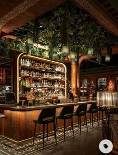 the bar is decorated with greenery and hanging from the ceiling, along with black chairs