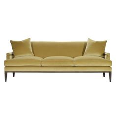 a yellow couch with two pillows on top of it and one pillow in the middle