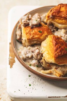 a plate filled with meat and potatoes covered in gravy on top of a table