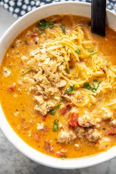 a bowl of slow cooker beef and potato soup with parmesan cheese on top