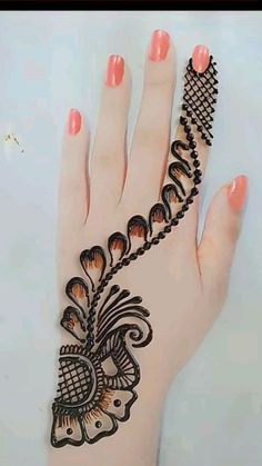 a hand with henna on it that is decorated with flowers and leaves, sitting on a white surface