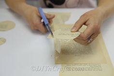 a person is cutting paper with a pen