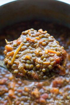 a spoon full of lentils and carrots in a pot