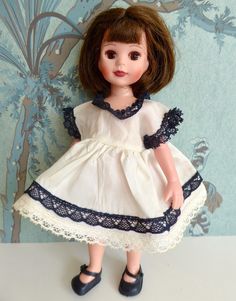 THIS WONDERFUL VINTAGE DOLL DRESS BEARS ALL THE STYLISTIC MARKS OF THE 1950s, when this dress and many in our Etsy shop were created.  These mid century years were arguably the pinnacle of mass-market yet high-quality dolls and doll clothing and doll furniture, and this dress is good example.  The monochrome combination of black and white was popular, as was the very full skirt, and here you have both.  The little dress is made from silky white taffeta and trimmed with black lace, making it read Vintage Doll Dress, Doll Party, Mass Market, 50s Dresses, Madame Alexander, Lace Making, Vintage Doll, Doll Clothing, Doll Furniture