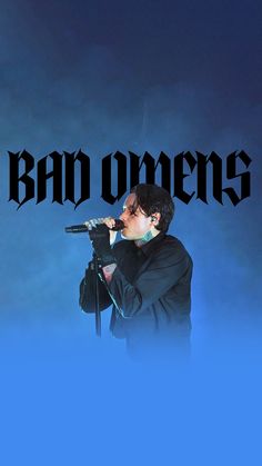 a man holding a microphone in front of a blue background with the words bad ones on it