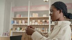 a woman holding a shopping bag in front of a store shelf with other items on it