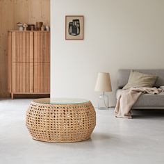 a living room with a couch, table and lamp on the floor in front of it