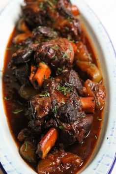 a white plate topped with meat and carrots covered in gravy