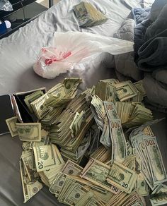 a pile of money sitting on top of a bed