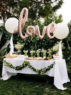 an image of a table with balloons that say love on it and some food in the foreground