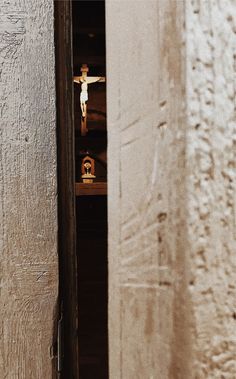 an open door with a crucifix in the background