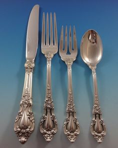 an assortment of silverware including forks, knives and spoons on a blue background