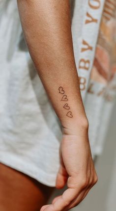 a person with a small tattoo on their left arm and the word love written in cursive font