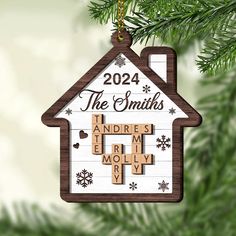 a personalized ornament hanging from a christmas tree with the name and cross on it