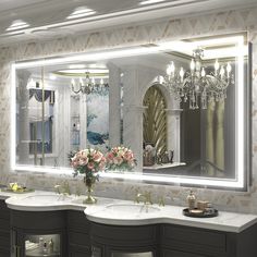 a bathroom with two sinks and a large mirror over it's sink, in front of a chandelier