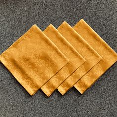 four yellow napkins sitting on top of a carpet