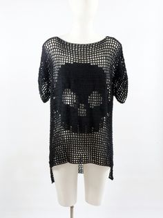 a white mannequin wearing a black knitted shirt with skulls on the front