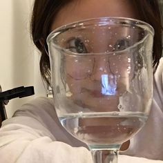 a woman holding a glass with water in it