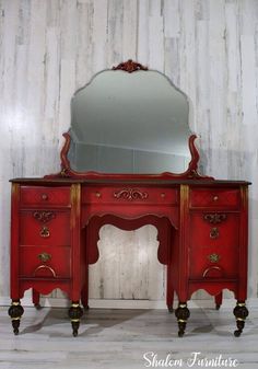 a red dresser with a mirror on top of it