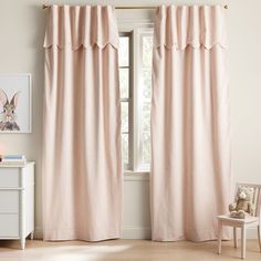 the curtains in this room are pink and have ruffles on them, along with a teddy bear